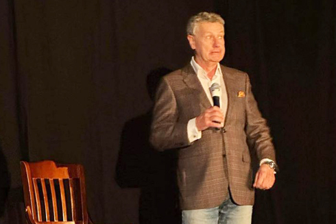 Dave Caperton onstage with chair