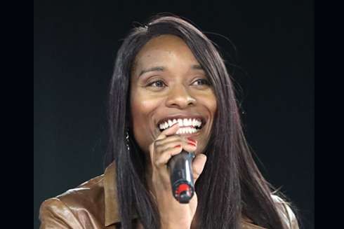 Remarkable Speakers Bureau Genein Letford leather jacket onstage